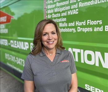 female, gray servpro shirt posing in from of truck