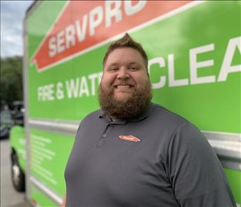 employee, bearded, gray shirt, in front of truck