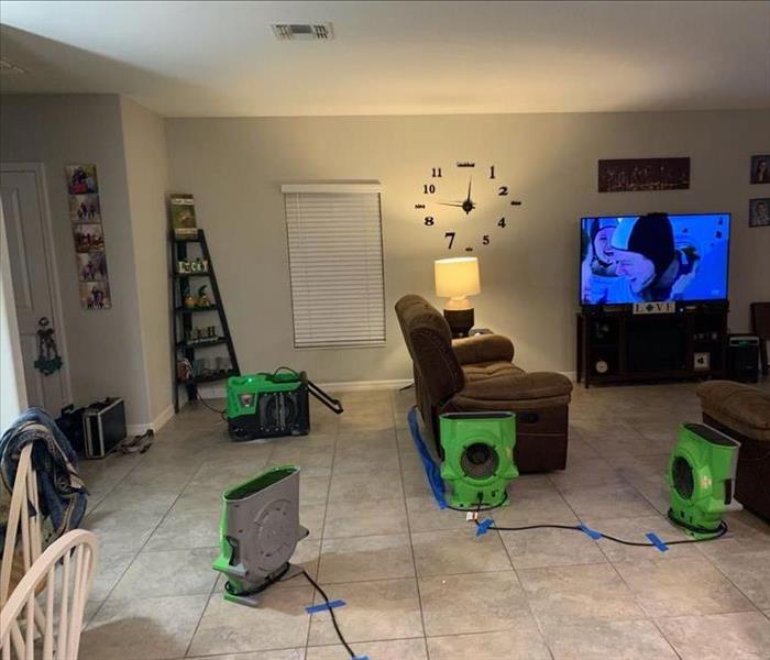 Air movers and dehumidifiers with cords taped down in the living room