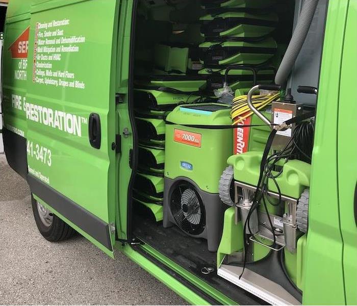 Green fleet service van open to show water mitigation equipment
