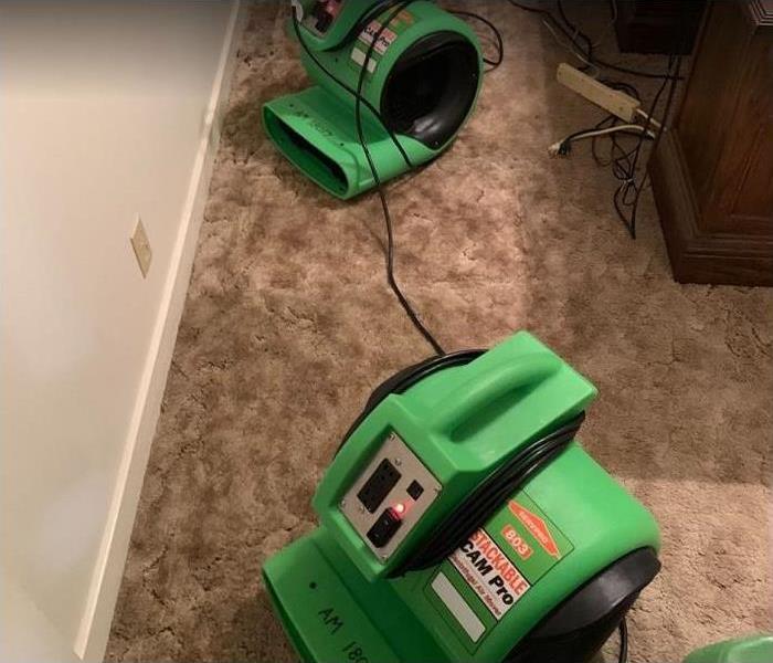 SERVPRO restoration equipment being used to dry carpet in water damaged room