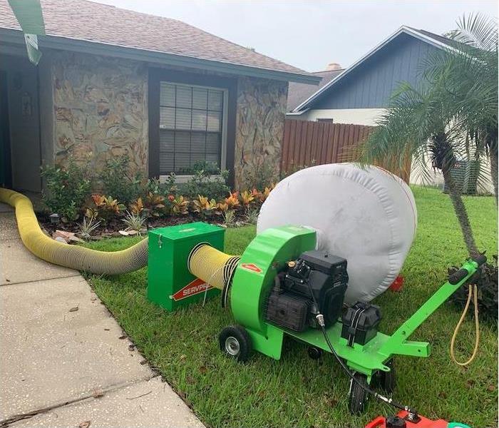HEPA cleaning vacuum set up outside a home with mold damage