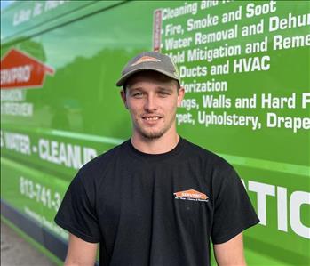 male, servpro shirt and hat in front of truck
